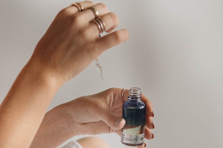 person holding black glass bottle